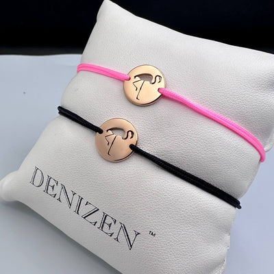 Two DENIZEN rose gold bracelets with an flamingo cutout on pink and black strings