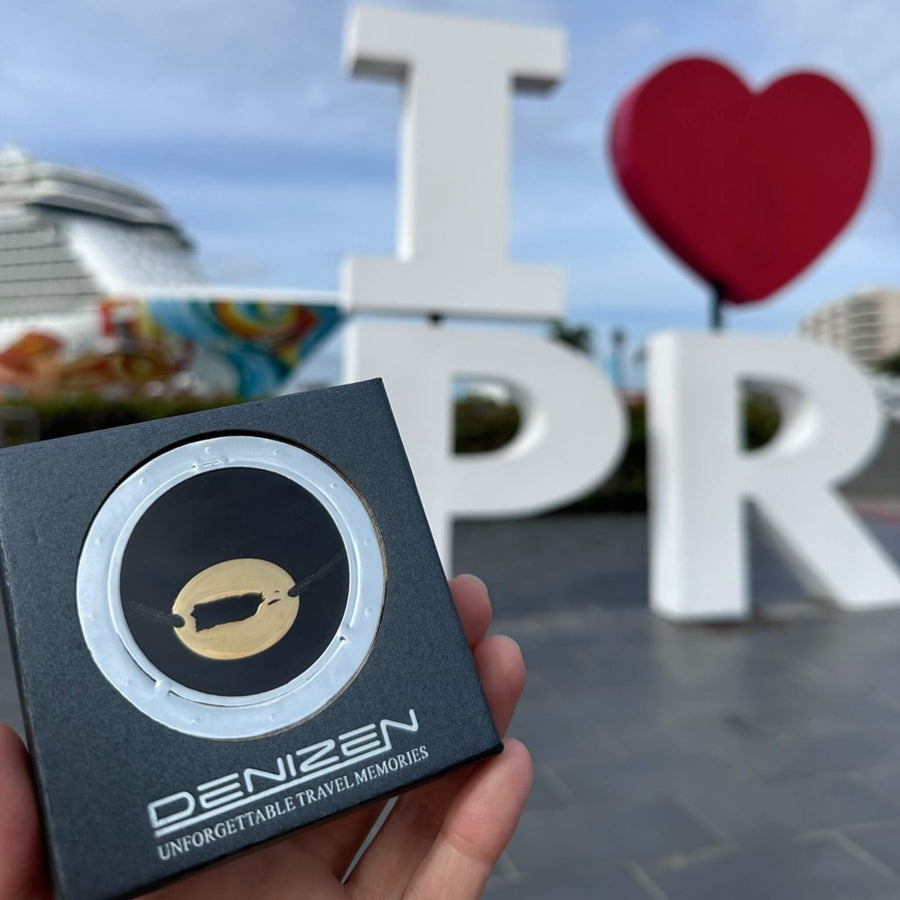 DENIZEN gold Puerto Rico bracelet in gift box held in front of 'I ❤️ PR' sign